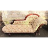 A Victorian walnut chaise longue with raised back and scrolled end raised on four turned supports,