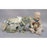 A late 19th century oriental model of a seated baby holding a bird, with open mouth and painted