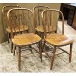 A set of four stained beechwood hoop back dining chairs with turned spindle backs over solid seats