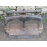 A small but heavy cast iron book/paper press with central screw thread with label Joslins. L.