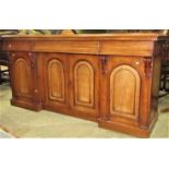A Victorian mahogany sideboard fitted with three ogee moulded frieze drawers over four arched and