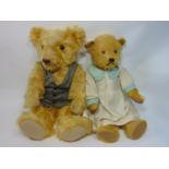 2 old teddy bears, both with golden fur, slightly humped back, long limbs, glass eyes and stitched