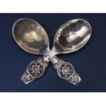 Good pair of arts and crafts cast silver caddy type spoons with applied quatrefoils crest type