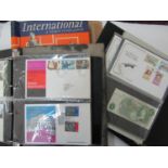 Three albums containing a collection of FDC's, a few British Post Office mint stamp collections