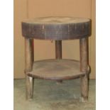 A rustic elm two tier occasional table of circular form, ethnic or of Eastern origin with carved