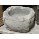 An early carved natural stone mortar or quern 30cm in diameter approximately