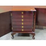 A small mahogany and stained pine table top collectors cabinet enclosed by a single door fitted with