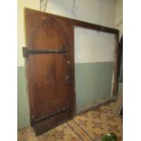 A lancet shaped English oak church internal door with exposed iron strap work hinges and fittings,