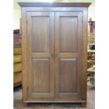 A small Georgian oak hanging cupboard enclosed by a pair of fielded panelled doors beneath a moulded