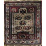 A small Persian wool rug on a white ground, with small geometric repeating lozenge detail, set