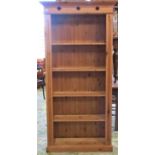 A stripped pine freestanding open bookcase with four fixed shelves and pierced quadrofoil detail, 90