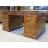 A Georgian style kneehole twin pedestal desk with dark green leather inset panelled top over an