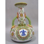 A 19th century French tin glazed earthenware two handled vase with drawn neck and polychrome painted