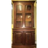 Victorian mahogany library bookcase, the base enclosed by two arched and moulded panelled doors