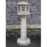 A weathered contemporary cast composition stone three sectional bird table of octagonal form with