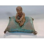 19th century terracotta study of a seated nude child fixed upon a velvet cushion, 12 cm high
