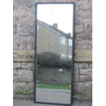 A wall mounted full length dressing mirror with simple moulded ebonised frame, 125 cm x 48 cm