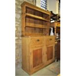 A reclaimed stripped pine kitchen dresser, the base enclosed by a pair of rectangular panelled doors