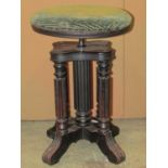 A music/piano stool with circular revolving upholstered pad seat, raised on reeded columns and