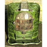 A French cast iron and green enamel stove enclosed by a bow fronted arched panelled door within a