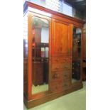 An inlaid Edwardian mahogany triple compactum wardrobe with chequered banding, partially enclosed