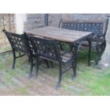 A heavy cast iron framed four piece garden suite comprising rectangular table, two seat bench and