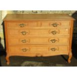 A medium to light oak commode fitted with three long and two short drawers raised on scrolled