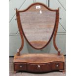A Georgian mahogany toilet mirror, the shield shaped frame supported on a pair of tapering horns,