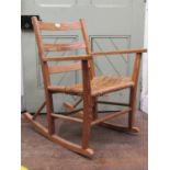 A simple country made pine framed rocking chair with ladderback and seagrass seat