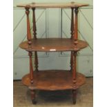 A Victorian figured walnut three tier etagere with repeating marquetry detail raised on turned