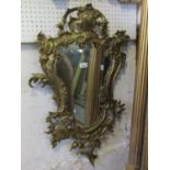 A shield shaped wall mirror with cast gilt metal rococo style frame, 82 cm x 54 cm approx