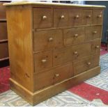 A Victorian style stripped pine floorstanding multi-drawer chest fitted with an arrangement of