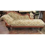 A Victorian mahogany chaise longue, the raised back and scrolled end with show wood detail raised on