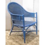 A vintage wicker and cane chair labelled dryad, with arched back and blue painted finish