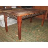 An Indian hardwood dining table of rectangular form with cast repeating looped lattice metal
