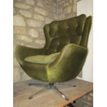 A vintage swivel egg type chair upholstered in green dralon with buttoned cushioned back raised on a