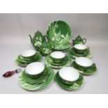 A collection of oriental eggshell porcelain teawares with iris decoration in tones of green,