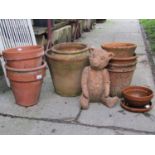 A small quantity of weathered terracotta flower pots and planters of varying size and design,