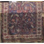 An old Persian wool rug with bluer ground, multi and abstract detailed centre panel, within