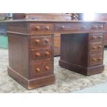 A Victorian walnut kneehole twin pedestal desk with inset faux leather panelled top over an
