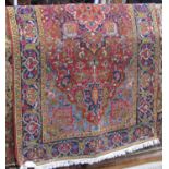 A coarse wool Persian style carpet with red field and further geometric detail within alternating