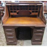 A twin pedestal oak roll top desk, the serpentine roll enclosing a fitted interior over the usual