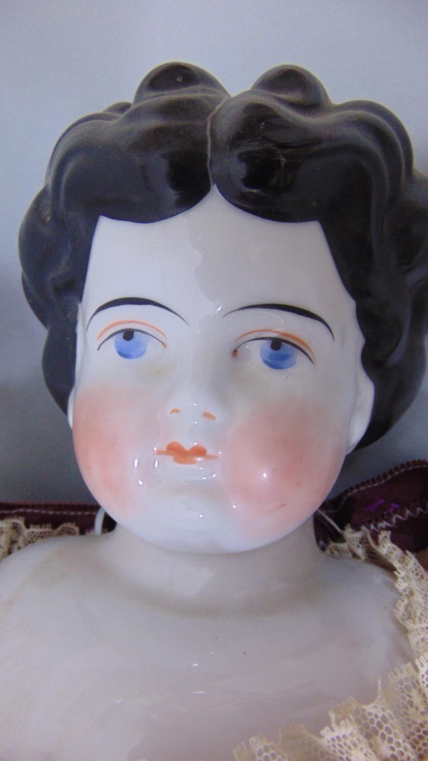 Early glazed china shoulder-head doll, German circa 1890, with finely painted blue eyes, red line to - Image 2 of 2