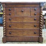 A substantial Victorian mahogany bedroom chest fitted with an arrangement of nine drawers flanked by
