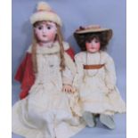 2 large well dressed bisque head dolls with jointed composition bodies, pierced ears, open mouth
