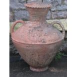 A weathered terracotta jar/amphora with moulded loop handles, flared neck and tapered globular body,