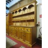 A large Victorian style pine kitchen dresser, the base enclosed by five rectangular panelled doors