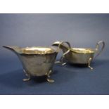 Two Georgian style silver cream jugs both with wavy rims and cabriole feet by Joseph Gloster and