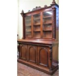 A Victorian mahogany three door library bookcase, the lower section enclosed by three arched and