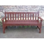 A stained teak three seat garden bench with slatted seat and back, 5ft long approx